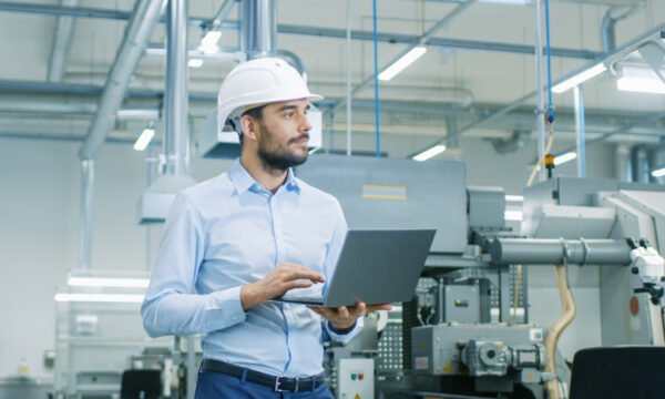 Un consultant avec son ordinateur dans une usine